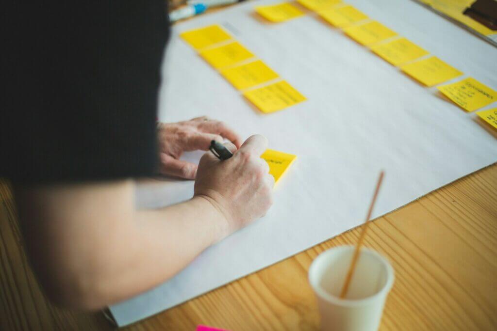 a person writing on a piece of paper planning out their web content strategy